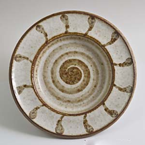 designed by maria philippi for soholm a small bowl/tray with a spiral pattern in brown on a cream colored background